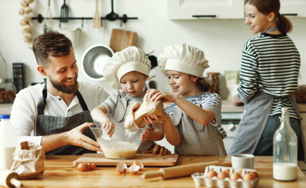 istock Cheerful kids with parents making dough at home 1270396666