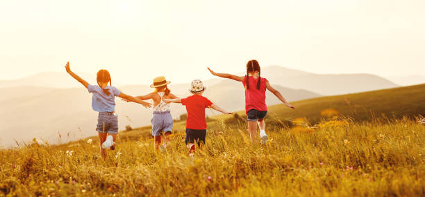 istock Anonymous happy children running backin field 1270399167
