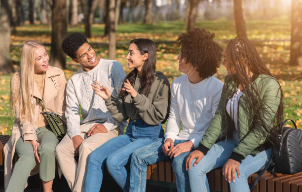 istock Cheerful international students having break in park 1270399393