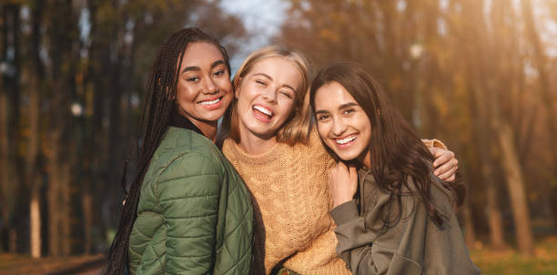 портрет трех молодых подруг, проводя время в парке - women autumn teenage girls teenager стоковые фото и изображения