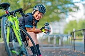 Portrait of female biker smiling for camera in public park
