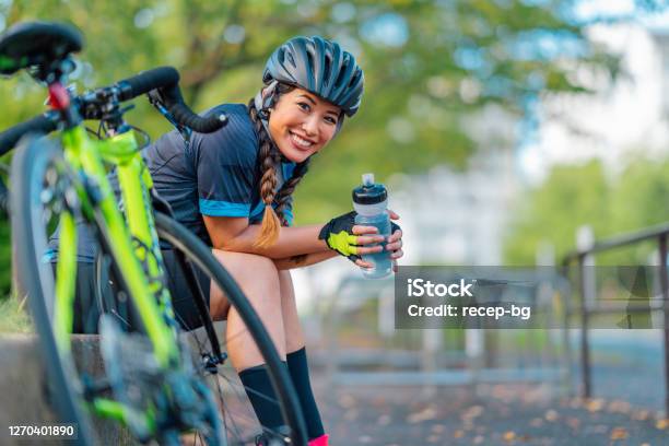 Portrait Of Female Biker Smiling For Camera In Public Park Stock Photo - Download Image Now