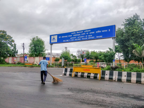 indore, india - august 22nd 2020: municipality worker cleaning road outside indore airport. cleanest city in india 2020. - india car people business imagens e fotografias de stock