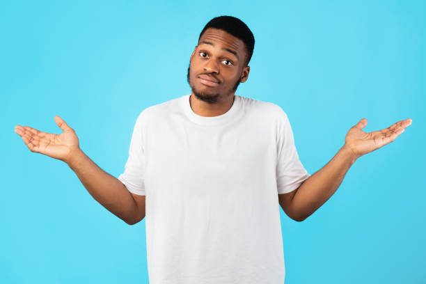 Young Black Man Shrugging Shoulders Posing Over Blue Background