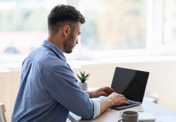 istock Busy Male Entrepreneur Working On Laptop With Black Screen In Office 1270403231