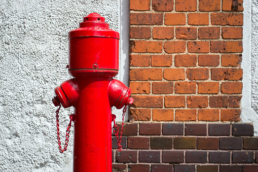 old red fire hydrant against the brick wall