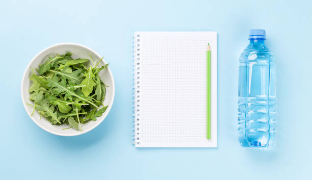 Healthy food and weigh loss concept Healthy food and weigh loss concept. Top view flat lay with notepad for your fitness or diet plan bottled water on table stock pictures, royalty-free photos & images
