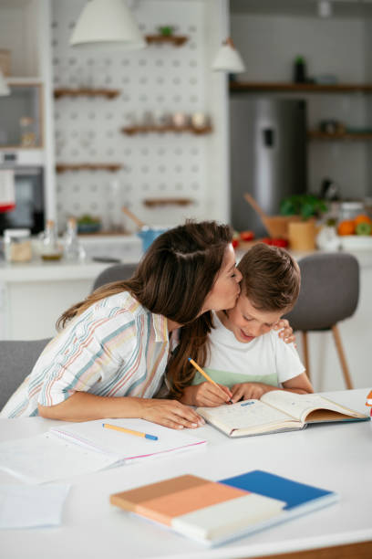 istock Mother helping her son with homework at home. 1270405755