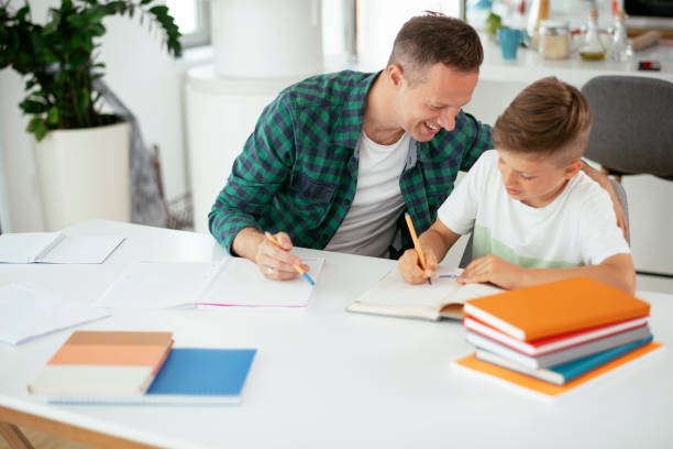 istock Father helping her son with homework at home. 1270406534