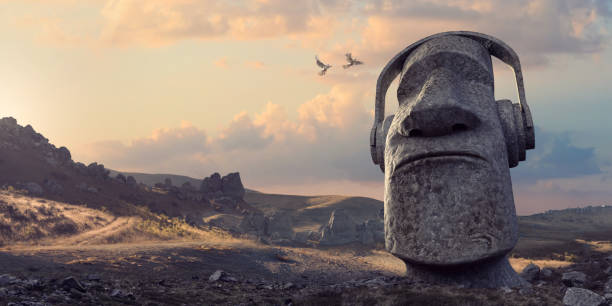 Stone Statue Head Wearing Headphones In Remote Rocky Dawn Landscape A single large Moai style stone head statue wearing headphones as if listening to music, formed from solid rock, buried in the ground from the neck down. The statue is located in a generic remote rocky landscape at dawn, as two birds fly towards it. With copy space. mythology photos stock pictures, royalty-free photos & images