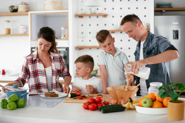istock Mother and father making breakfast with sons. 1270407078