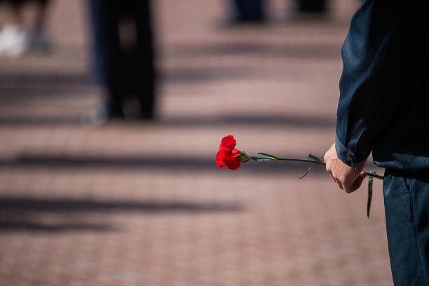 istock Holds red carnations, a memorable day of mourning. 1270407724