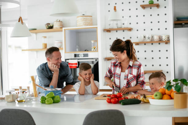 istock Mother and father making breakfast with sons 1270407742