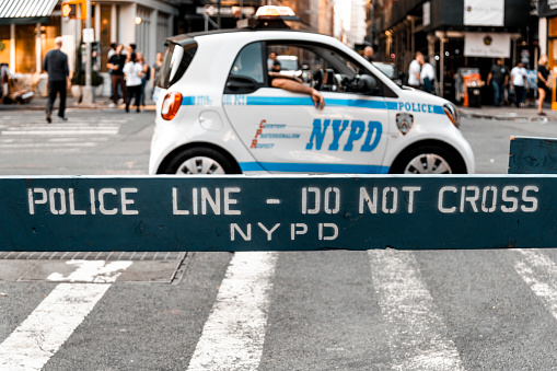 Police Line, do not cross the sign in front of the police car in Little Italy during The Feast of San Gennaro, New York.