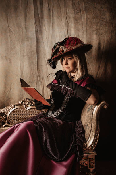 istock Blond model in historical victorian dress reading a book 1270409796