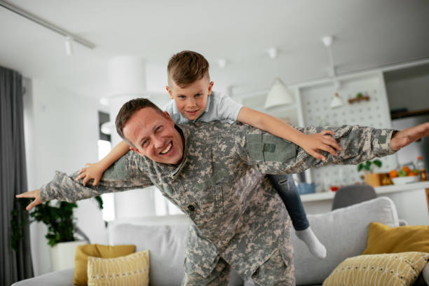 soldato che si diverte con suo figlio a casa - young soldier foto e immagini stock