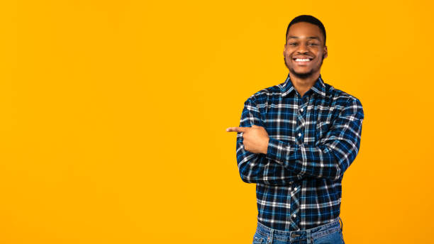 istock Cheerful Black Guy Posing Pointing Finger Aside In Studio, Panorama 1270411178