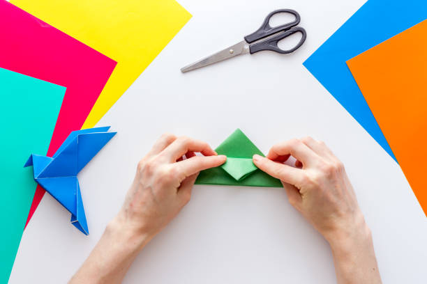 istock DIY concept. Doing origami paper bird, Top view 1270411196