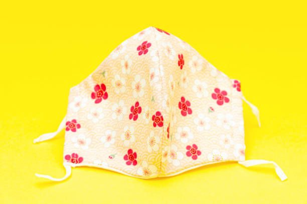istock Floral pattern DIY fabric face mask for protection against Coronavirus (COVID-19) and other infectious diseases. Isolated on yellow background. Close-up. Horizontal shot 1270411229