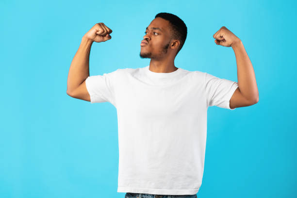 istock Strong African American Man Showing Biceps Standing Over Blue Background 1270411259