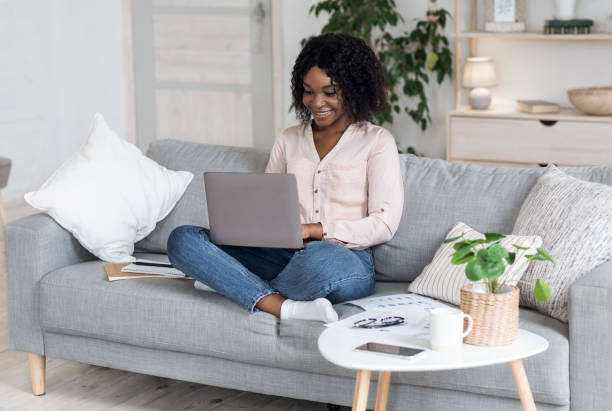 istock Remote Work. Joyful Black Woman Working On Laptop On Couch At Home 1270411588