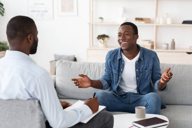 istock Successful Therapy. Cheerful black man talking to psychologist at his office 1270412448
