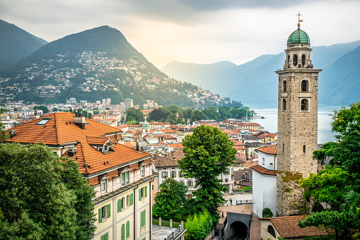 Paisaje urbano escénico de Lugano con el campanario de la catedral de San Lorenzo y vista al lago y luz dramática en Lugano Ticino Suiza photo