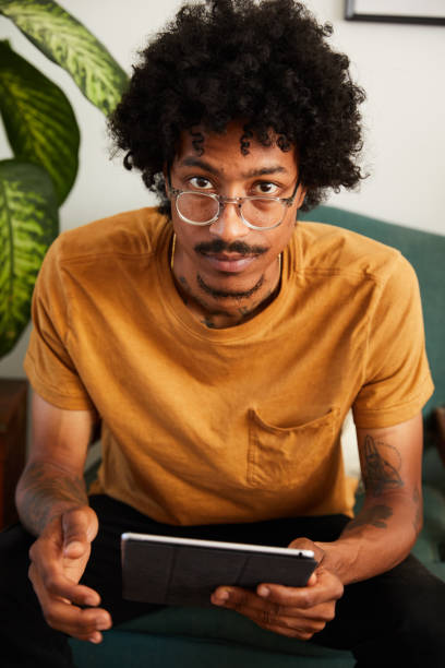 istock Young man using a tablet in his living room at home 1270413732