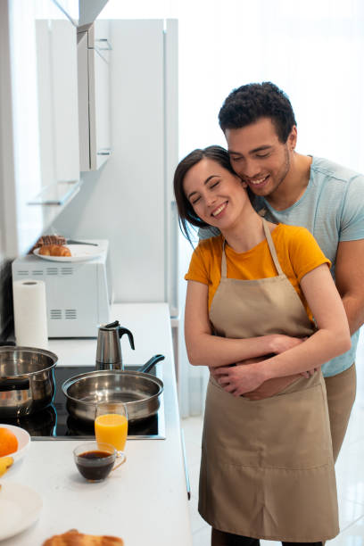 istock Cute attractive couple hugging in the kitchen with closed eyes 1270414032