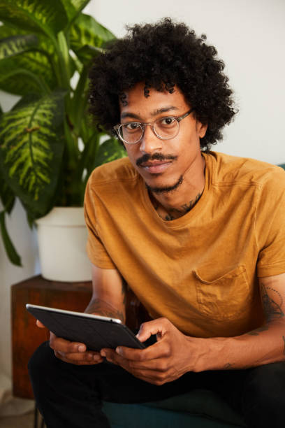 istock Young man sitting at home using a tablet to browse the internet 1270414057