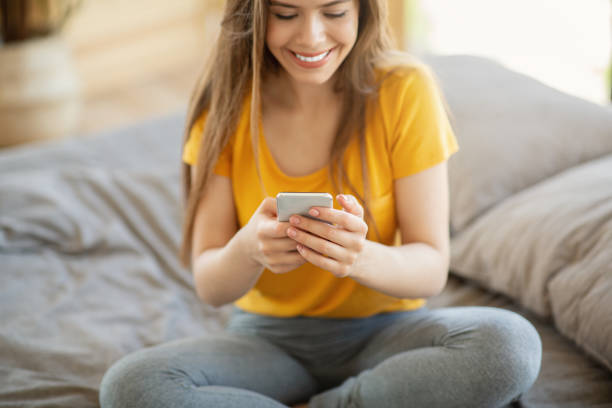 istock Attractive blonde girl using cellphone for online communication, work or studying on bed at home 1270415238