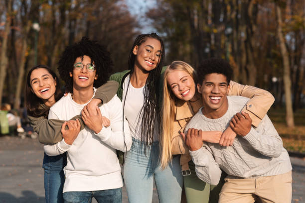 grupo positivo de jovens amigos se divertindo em parque público - early teens - fotografias e filmes do acervo