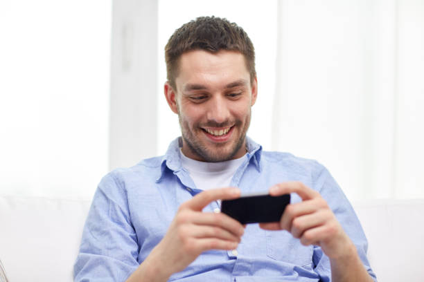 istock happy man with smartphone at home 1270415716