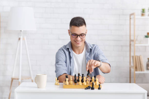 istock Virtual opponent in chess game. Smiling guy playing board game at online call 1270416583
