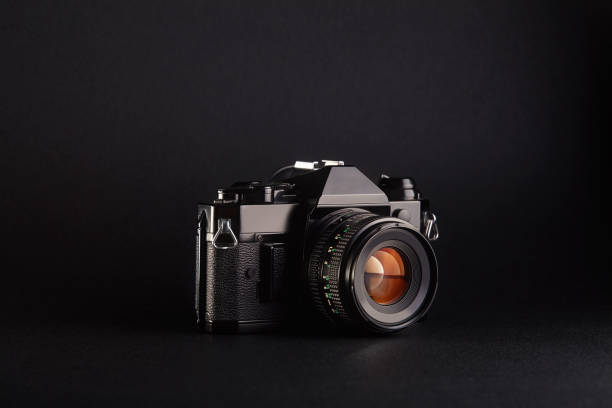 istock Old-fashioned vintage film camera with lens on black background 1270416593