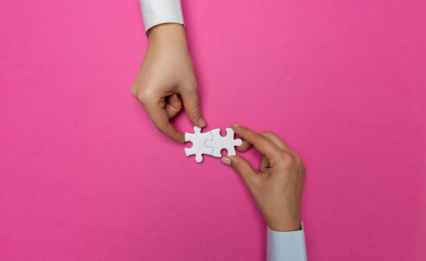 Hands with Puzzle Pieces Business people are merging two puzzle pieces. pink promise stock pictures, royalty-free photos & images