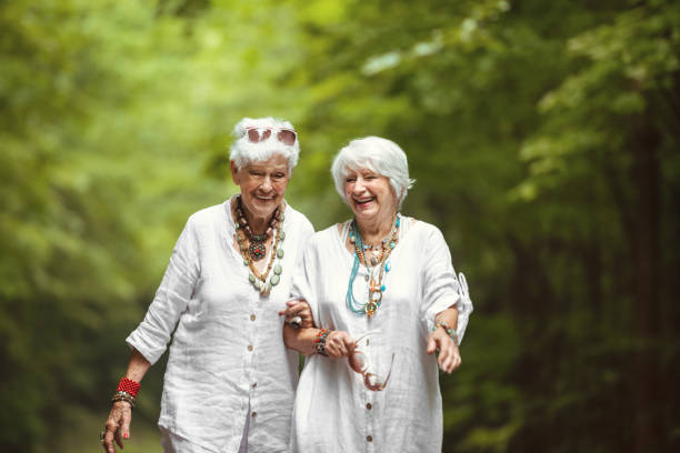 Senior best friend women walking in nature stock photo