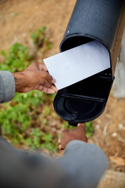 man removing a letter from his mailbox - looking into mailbox imagens e fotografias de stock