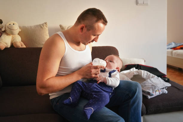 istock Young man feeding milk his baby boy son from bottle 1270430022