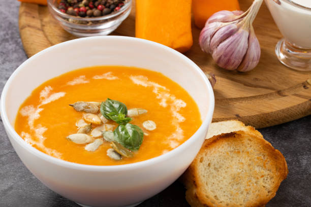 istock Pumpkin cream soup with seeds on a stone background 1270435748
