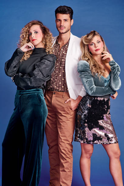 We're off to a 80s themed party Shot of three young people posing together in 80s clothing against a blue background vibrant color lifestyles vertical close up stock pictures, royalty-free photos & images