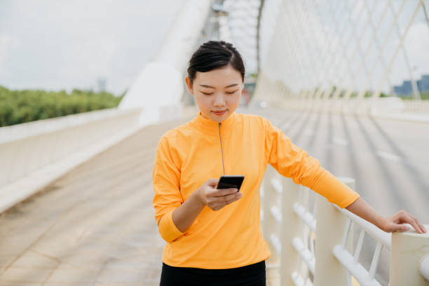 istock Sporty young Asian Chinese woman using smart phone and resting 1270438231