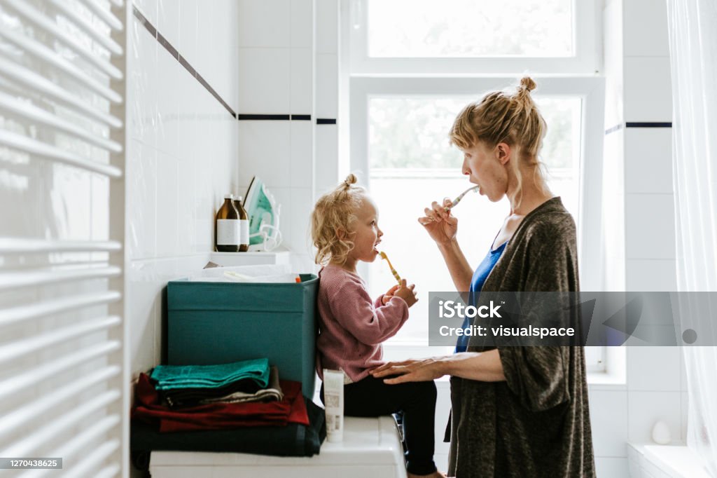 Young mother with a child brushing teeth in the morning Photo series of a young mother with a child doing different chores at home. Shot in Berlin. Child Stock Photo