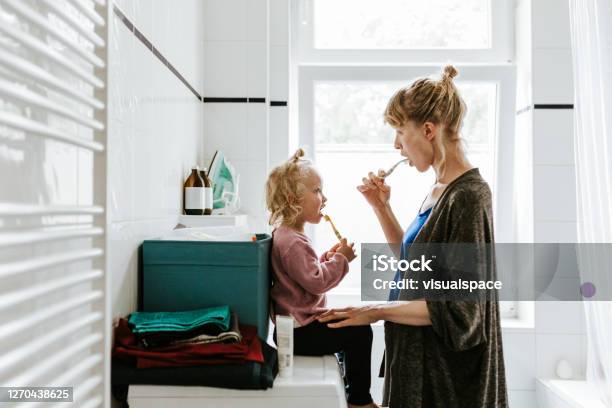 Young Mother With A Child Brushing Teeth In The Morning Stock Photo - Download Image Now