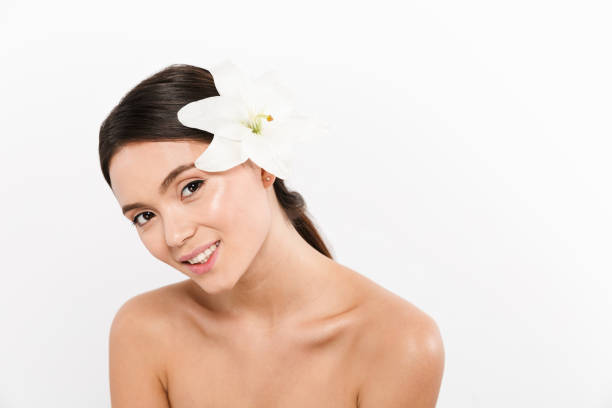 Portrait of beautiful woman with pink lily on white background