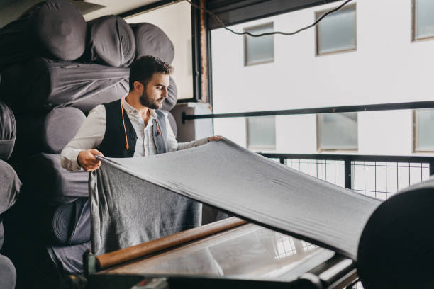 small business owner checking the fabric for the last time - textile textile industry warehouse store imagens e fotografias de stock