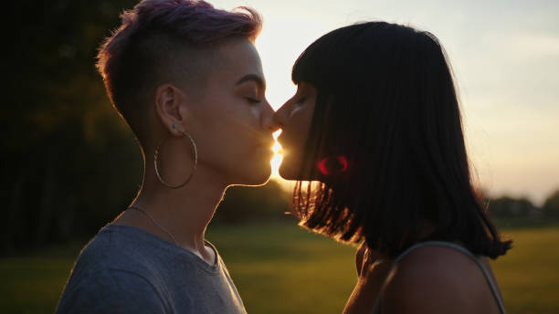 крупным планом портрет двух лесбиянок, целующихся на закате - lesbian homosexual kissing homosexual couple стоковые фото и изображения