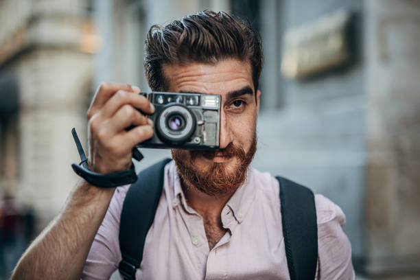 istock Modern man taking pictures with camera on the street downtown 1270447574