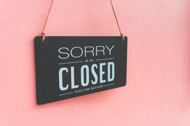 istock Sorry we're closed sign.  image hanging on in pink wall 1270451590