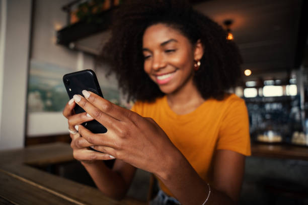 istock Beautiful female scrolling on smartphone while sitting in authentic coffee shop 1270455137